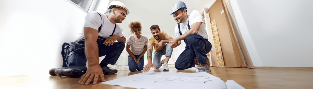 Artisans et clients discutent d'un plan d'aménagement intérieur