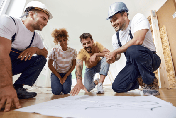 Artisans et clients discutent d'un plan d'aménagement intérieur