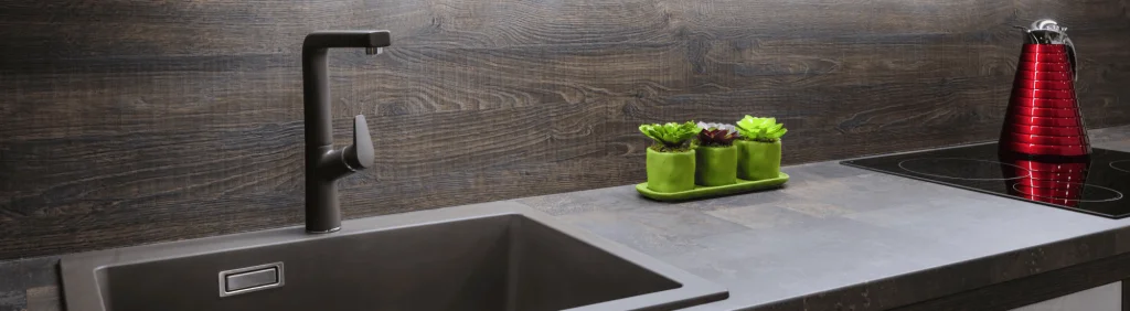 Image décorative. Un évier de cuisine moderne avec robinetterie noire.