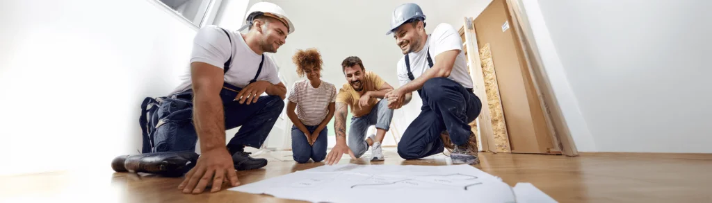 Artisans et clients discutent d'un plan d'aménagement intérieur