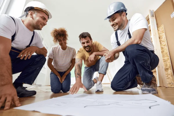 Artisans et clients discutent d'un plan d'aménagement intérieur
